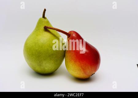 Pere fresche verdi e rosse su sfondo bianco. Due pere insieme. Concetto di relazione d'amore..... Foto Stock