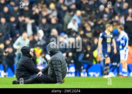 Reading, Regno Unito, 13 gennaio 2024. Il primo dei tanti fan ad invadere il campo raggiunge il cerchio centrale, costringendo il gioco a fermarsi. Protestando contro la proprietà del Reading FC e rifiutandosi di lasciare il campo, la partita, in casa del Port vale, viene formalmente abbandonata più di un'ora dopo. Crediti: TeeGeePix/Alamy Live News Foto Stock