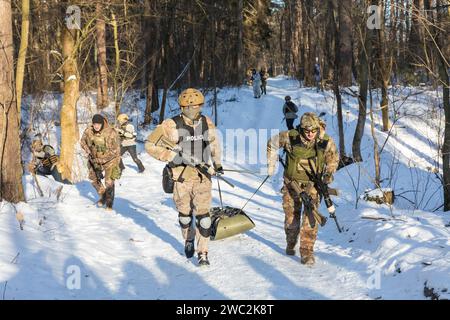 I soldati vengono visti praticare un'esercitazione di soccorso per i civili durante un'esercitazione militare. Addestramento militare per civili. I civili ucraini prendono parte all'esercizio finale di un corso approfondito di cinque giorni sulla preparazione dei cittadini alla resistenza nazionale nei pressi di Kiev durante l'invasione russa dell'Ucraina. Foto Stock