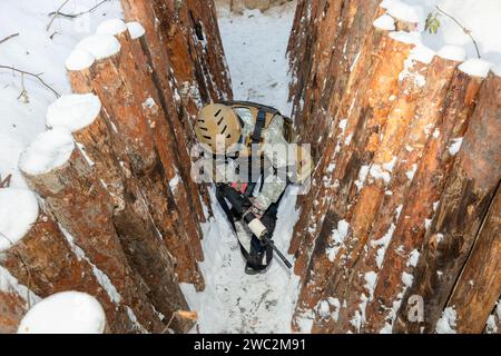 Kiev, Ucraina. 12 gennaio 2024. Un combattente viene visto con un fucile d'assalto in una trincea durante un'esercitazione militare per civili. Addestramento militare per civili. I civili ucraini prendono parte all'esercizio finale di un corso approfondito di cinque giorni sulla preparazione dei cittadini alla resistenza nazionale nei pressi di Kiev durante l'invasione russa dell'Ucraina. (Foto di Mykhaylo Palinchak/SOPA Images/Sipa USA) credito: SIPA USA/Alamy Live News Foto Stock