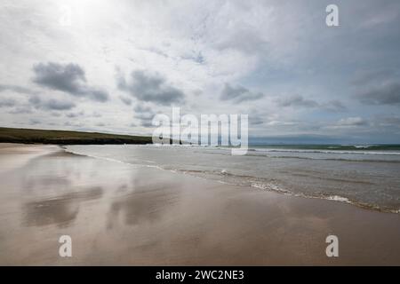 Ampia distesa di sabbia sulla spiaggia di Aberffraw sulla costa occidentale di Anglesey. Vista sulle montagne della terraferma all'orizzonte. Foto Stock