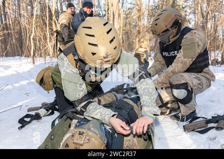 Kiev, Ucraina. 12 gennaio 2024. I soldati vengono visti praticare un'esercitazione di soccorso per i civili durante un'esercitazione militare. Addestramento militare per civili. I civili ucraini prendono parte all'esercizio finale di un corso approfondito di cinque giorni sulla preparazione dei cittadini alla resistenza nazionale nei pressi di Kiev durante l'invasione russa dell'Ucraina. (Immagine di credito: © Mykhaylo Palinchak/SOPA Images via ZUMA Press Wire) SOLO USO EDITORIALE! Non per USO commerciale! Foto Stock