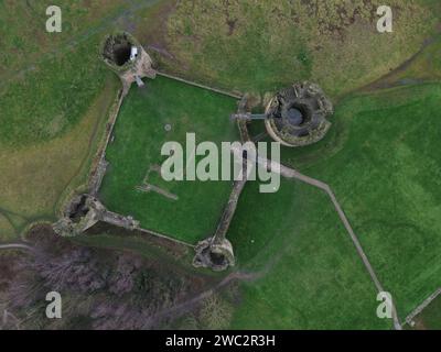 Foto aerea di un castello abbandonato circondato da un lussureggiante prato artificiale Foto Stock