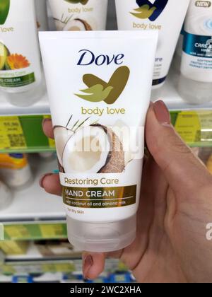 04.10.2023 Ucraina, Kharkov: Crema mani dove su uno scaffale del negozio. bottiglia di panna in mano. Cura delle mani idratante crema per le mani Foto Stock