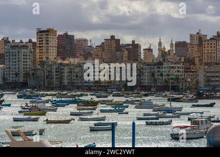 Alessandria, Egitto - 29 gennaio 2021: Vista del porto dalla Cittadella di Qaitbay ad Alessandria, Egitto. Molte barche sull'acqua contro gli edifici della città. Foto Stock