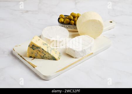Pezzi di brie, camembert, formaggio di capra e formaggio con muffa blu su tavola di legno Foto Stock