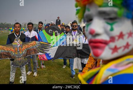 NUOVA DELHI, INDIA - 13 GENNAIO: Persone che volano aquiloni durante il primo festival internazionale degli aquiloni - "Patang Utsav" a Baansera, il primo parco a tema di bambù della città a sarai Kale Khan sulle rive del fiume Yamuna, il 13 gennaio 2024 a nuova Delhi, India. Il festival di due giorni è organizzato dalla Delhi Development Authority (DDA) e vedrà oltre 30 kitisti professionisti provenienti da Rajasthan, Sikkim, Maharashtra, Karnataka, Punjab, Lakshadweep e Gujarat espongono la loro arte. Aquiloni di varie forme, dimensioni e colori. (Foto di Raj K Raj/Hindustan Times/Sipa USA ) Foto Stock