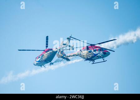 MUMBAI, INDIA - 13 GENNAIO: Il team aerobatico Indian Air Force Surya Kiran, il team elicottero Sarang e gli aerei Sukhoi si esibiscono al Marine Drive mentre diverse persone assistono al Mumbai Air Show 2024, il 13 gennaio 2024 a Mumbai, India. L'evento comprende esibizioni acrobatiche da parte del Surya Kiran Aerobatic display Team (SKAT) e del team Helicopter display. Dispone anche di una gamma diversificata? Di attività aeree, tra cui un flypast e un'esibizione acrobatica di basso livello da parte del su-30 MKI, esposizioni di caduta libera e paracadute da parte del team Akashganga e aerei C-130. (Foto di Raju Shinde/Hindustan Times/Sipa USA Foto Stock