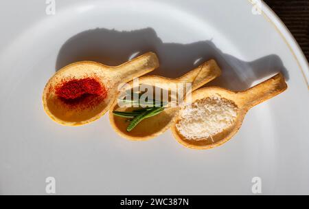 Specie a cucchiaio come zafferano e parmigiano e rosmarino con luce solare in Svizzera Foto Stock