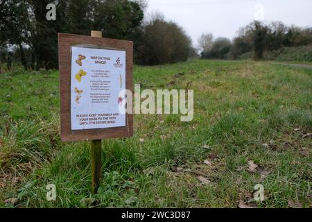 Gennaio 2024 - tieniti lontano dall'insegna in un'area di fiori selvatici appena piantati accanto alla pista ciclabile Strawberry Line a Yatton, nel nord del Somerset, Inghilterra, Regno Unito. Foto Stock