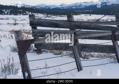 Cancello di legno in inverno che si apre e si sporge, con sfondo montano. Montagne della Sierra Nevada. Foto Stock