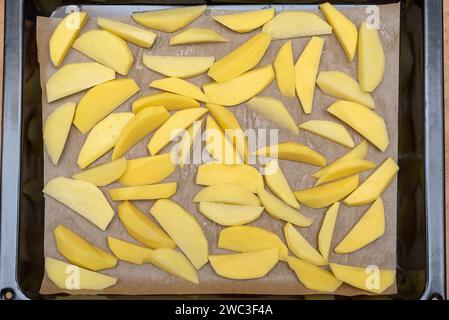 Vista dall'alto delle fette di patate crude su un vassoio da forno Cibo fatto in casa. Foto Stock