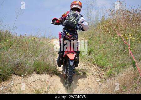 Nella gara di moto estreme Enduro i piloti hanno gareggiato su terreni difficili saltando sopra le gomme su un terreno e facendo un giro di 40 km su sentieri di montagna. Foto Stock