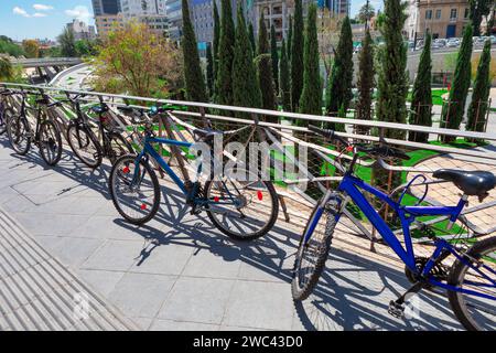 Biciclette parcheggiate in fila sul ponte pedonale del parco Foto Stock