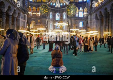 Istanbul, Turchia. 13 gennaio 2024. Un turista si umilia per pregare a Hagia Sophia. La Hagia Sophia, è stata trasformata da museo a moschea nel 2020 per decisione del presidente Erdogan, ai visitatori che sono turisti verrà addebitata una tassa di 25 euro a partire dal 15 gennaio 2024, con decisione del Ministero della Cultura e del Turismo. Credito: SOPA Images Limited/Alamy Live News Foto Stock