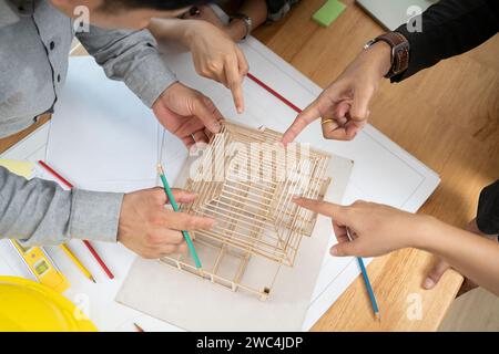 Un team di architetti asiatici parla della nuova struttura del tetto nel loro ufficio. Foto Stock