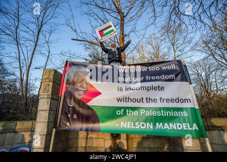 Un manifestante maschile tiene un cartello con un ritratto di Nelson Rolihlahla Mandela, durante l'audizione della Corte Internazionale di giustizia (ICJ). Il Sudafrica ha presentato la sua causa contro lo Stato di Israele durante la sua sessione di tre ore presso la Corte internazionale di giustizia (ICJ) dell'Aia. Il piano di Israele di "distruggere” Gaza proviene dal "livello più alto di stato”, sentito dalla corte suprema delle Nazioni Unite. Il Sudafrica ha anche invitato la (ICJ) a ordinare a Israele di cessare immediatamente tutte le azioni militari. Gli avvocati sudafricani hanno accusato il genocidio del pf israeliano. Israele, avrà il suo giorno alla (ICJ) per sfinanziare la sua difesa venerdì Foto Stock