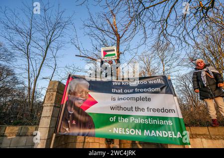 Un manifestante maschile tiene un cartello con un ritratto di Nelson Rolihlahla Mandela, durante l'audizione della Corte Internazionale di giustizia (ICJ). Il Sudafrica ha presentato la sua causa contro lo Stato di Israele durante la sua sessione di tre ore presso la Corte internazionale di giustizia (ICJ) dell'Aia. Il piano di Israele di "distruggere” Gaza proviene dal "livello più alto di stato”, sentito dalla corte suprema delle Nazioni Unite. Il Sudafrica ha anche invitato la (ICJ) a ordinare a Israele di cessare immediatamente tutte le azioni militari. Gli avvocati sudafricani hanno accusato il genocidio del pf israeliano. Israele, avrà il suo giorno alla (ICJ) per sfinanziare la sua difesa venerdì Foto Stock