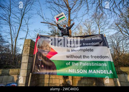 Un manifestante maschile tiene un cartello con un ritratto di Nelson Rolihlahla Mandela, durante l'audizione della Corte Internazionale di giustizia (ICJ). Il Sudafrica ha presentato la sua causa contro lo Stato di Israele durante la sua sessione di tre ore presso la Corte internazionale di giustizia (ICJ) dell'Aia. Il piano di Israele di "distruggere” Gaza proviene dal "livello più alto di stato”, sentito dalla corte suprema delle Nazioni Unite. Il Sudafrica ha anche invitato la (ICJ) a ordinare a Israele di cessare immediatamente tutte le azioni militari. Gli avvocati sudafricani hanno accusato il genocidio del pf israeliano. Israele, avrà il suo giorno alla (ICJ) per sfinanziare la sua difesa venerdì Foto Stock