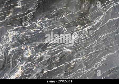 Roccia granitica sul taglio, colore grigio con strati chiari, texture di alta qualità Foto Stock