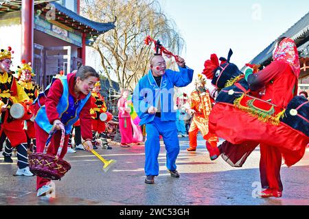 YANTAI, CINA - 14 GENNAIO 2024 - artisti popolari eseguono costumi popolari locali per celebrare il prossimo Festival di Primavera al mercato della Cultura Orientale di Foto Stock