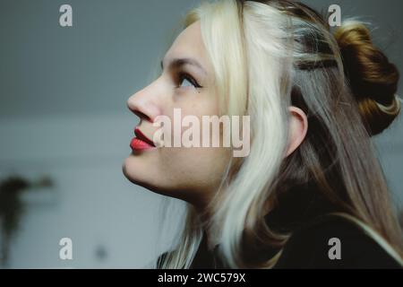 Una giovane donna vibrante è profondamente coinvolta nel mondo della musica, mentre ascolta con gioia i suoi brani preferiti attraverso il suo cellulare Foto Stock