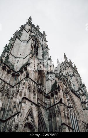 Dettagli sull'imponente facciata scolpita della storica York Minster nella contea dello Yorkshire, in Inghilterra. Preso in una giornata nuvolosa con cielo grigio. Foto Stock