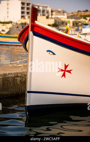 Tipica barca maltese, chiamata luzzo, con gli occhi tradizionali e la croce maltese disegnata sulla prua Foto Stock