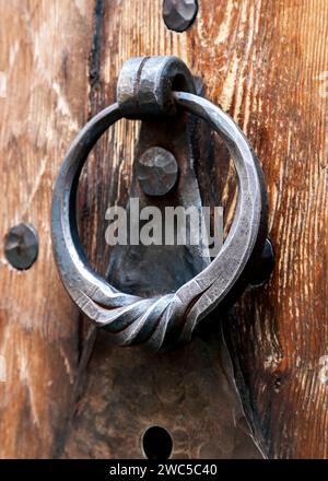 Anello di metallo porta respingente su un medievale porta di legno Foto Stock