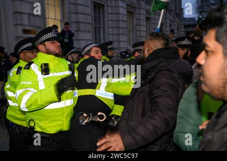 Manifestante pro-Palestina in uno scontro con la polizia alla fine di una marcia e di una manifestazione che chiedeva un cessate il fuoco dell’offensiva militare in corso di Foto Stock