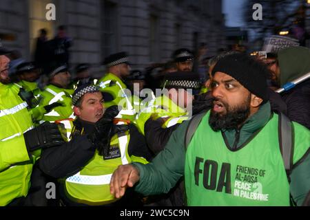 Manifestante pro-Palestina in uno scontro con la polizia alla fine di una marcia e di una manifestazione che chiedeva un cessate il fuoco dell’offensiva militare in corso di Foto Stock