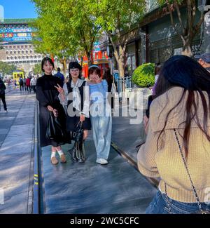 Pechino, Cina, gruppo di ragazze cinesi adolescenti, in posa per le foto, turisti che visitano il quartiere tradizionale, il quartiere Qianmen, tutto il corpo Foto Stock