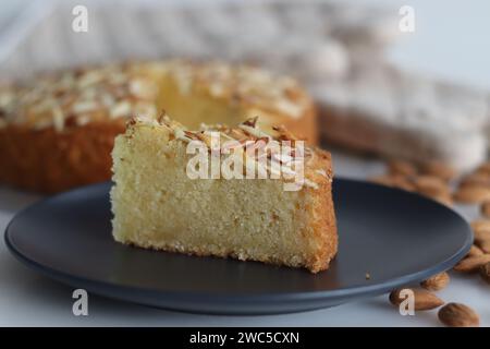 Torta al burro di mandorle a fette. Una deliziosa torta decorata con una spolverata generosa di mandorle tritate, perfetta per il tè. Facile da realizzare e visivamente Foto Stock