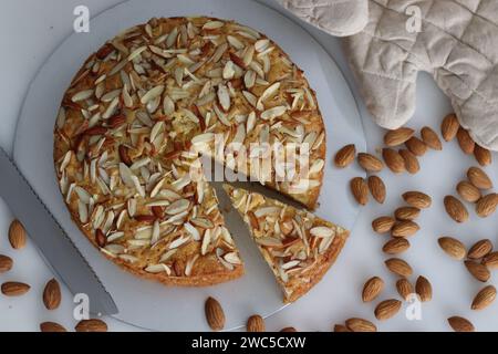 Torta al burro di mandorle a fette. Una deliziosa torta decorata con una spolverata generosa di mandorle tritate, perfetta per il tè. Facile da realizzare e visivamente Foto Stock