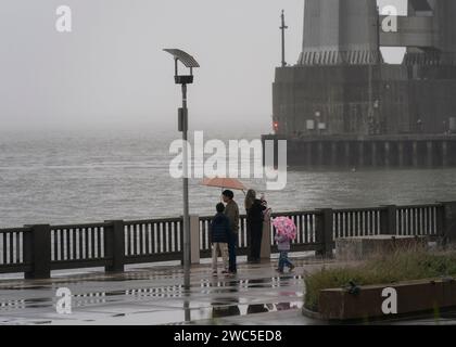 San Francisco, Stati Uniti. 13 gennaio 2024. La gente cammina in una strada sotto la pioggia a San Francisco, negli Stati Uniti, 13 gennaio 2024. Crediti: Li Jianguo/Xinhua/Alamy Live News Foto Stock