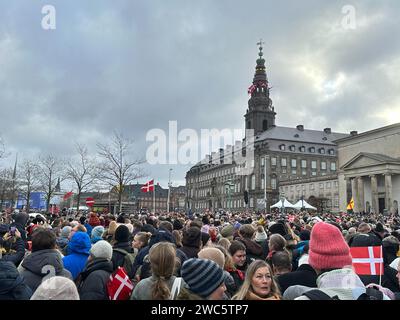 Copenhagen, Danimarca. 14 gennaio 2024. La gente si riunisce nella piazza del palazzo di Christiansborg. Dopo 52 anni di reggenza, la lunga regina Margrethe II consegna il trono domenica a suo figlio il principe ereditario Frederik, che in futuro porterà il titolo di re Frederik X. il primo ministro danese Frederiksen proclamerà il nuovo monarca dal balcone del palazzo nel pomeriggio. Crediti: Steffen Trumpf/dpa/Alamy Live News Foto Stock