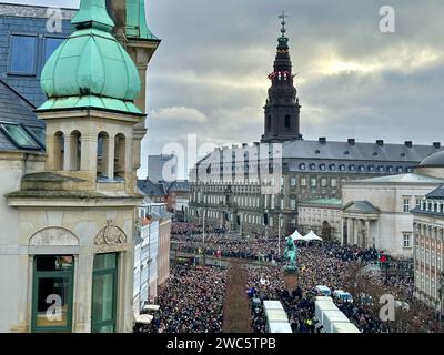 Copenhagen, Danimarca. 14 gennaio 2024. La gente si riunisce nella piazza del palazzo di Christiansborg. Dopo 52 anni di reggenza, la lunga regina Margrethe II consegna il trono domenica a suo figlio il principe ereditario Frederik, che in futuro porterà il titolo di re Frederik X. il primo ministro danese Frederiksen proclamerà il nuovo monarca dal balcone del palazzo nel pomeriggio. Crediti: Steffen Trumpf/dpa/Alamy Live News Foto Stock