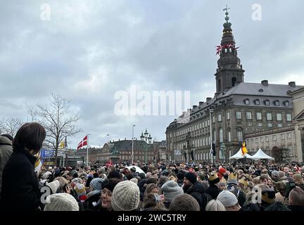 Copenhagen, Danimarca. 14 gennaio 2024. La gente si riunisce nella piazza del palazzo di Christiansborg. Dopo 52 anni di reggenza, la lunga regina Margrethe II consegna il trono domenica a suo figlio il principe ereditario Frederik, che in futuro porterà il titolo di re Frederik X. il primo ministro danese Frederiksen proclamerà il nuovo monarca dal balcone del palazzo nel pomeriggio. Crediti: Steffen Trumpf/dpa/Alamy Live News Foto Stock