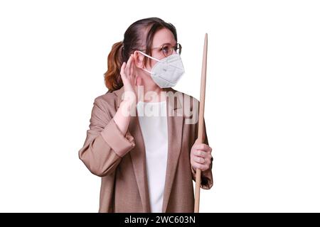 Donna insegnante in maschera medica mostra il gesto del segno di ascolto in studio isolato su uno sfondo bianco, copia spazio Foto Stock