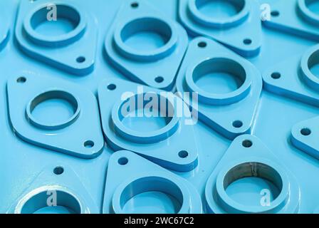 Parti metalliche per tubazioni verniciate di blu presso un'officina di verniciatura industriale. Profondità di campo ridotta con i componenti più vicini a fuoco. Foto Stock