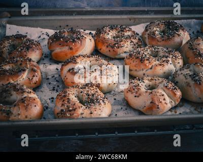 Bagel fatti in casa appena cucinati che escono da un forno caldo Foto Stock