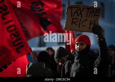 Davos, Svizzera. 14 gennaio 2024. Davos, CH 14 gennaio 2024. Un manifestante tiene un cartello durante una manifestazione contro il 54° Forum economico Mondiale. Centinaia di manifestanti si sono riuniti per esprimere preoccupazioni sull'agenda del WEF di quest'anno. Il Forum coinvolge i leader politici, commerciali e culturali della società per definire i programmi globali, regionali e industriali, che possono avere un impatto su tutti in tutto il mondo. Crediti: Andy Barton/Alamy Live News Foto Stock