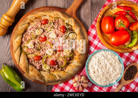 Pizza artigianale. Vista dall'alto della deliziosa pizza rustica con ingredienti. Foto Stock
