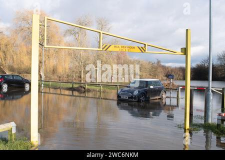 Wallingford, Oxfordshire, Regno Unito. 14 gennaio 2024. Il fiume Tamigi a Wallingford, Oxfordshire, è scoppiato questa settimana e ha inondato il Riverside Car Park. Alcune auto erano completamente sommerse dalle acque alluvionali. Un mini polo VW attendono il recupero. Credito: Maureen McLean/Alamy Live News Foto Stock