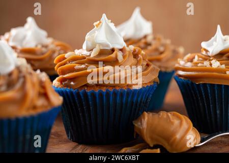 Deliziosi cupcake con dulce de leche su un tavolo di legno Foto Stock
