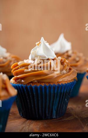 Deliziosi cupcake con dulce de leche su un tavolo di legno Foto Stock