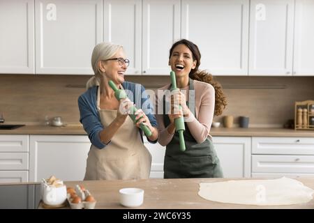 Felicissima madre anziana e donna figlia adulta che si divertono con l'attività culinaria Foto Stock
