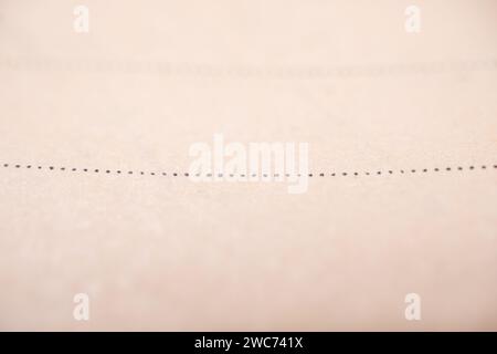 Una visione ravvicinata artistica di un pezzo di carta bianco con un delicato filo nero che emerge delicatamente da esso Foto Stock