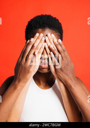 Ritratto di una giovane donna con gli occhi coperti dalle mani di un'altra donna. Foto Stock