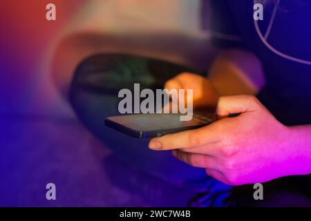 Social media al telefono. Concetto di Internet e rete su telefono cellulare. Ragazza felice che controlla i social media e tiene lo smartphone a casa. Foto Stock